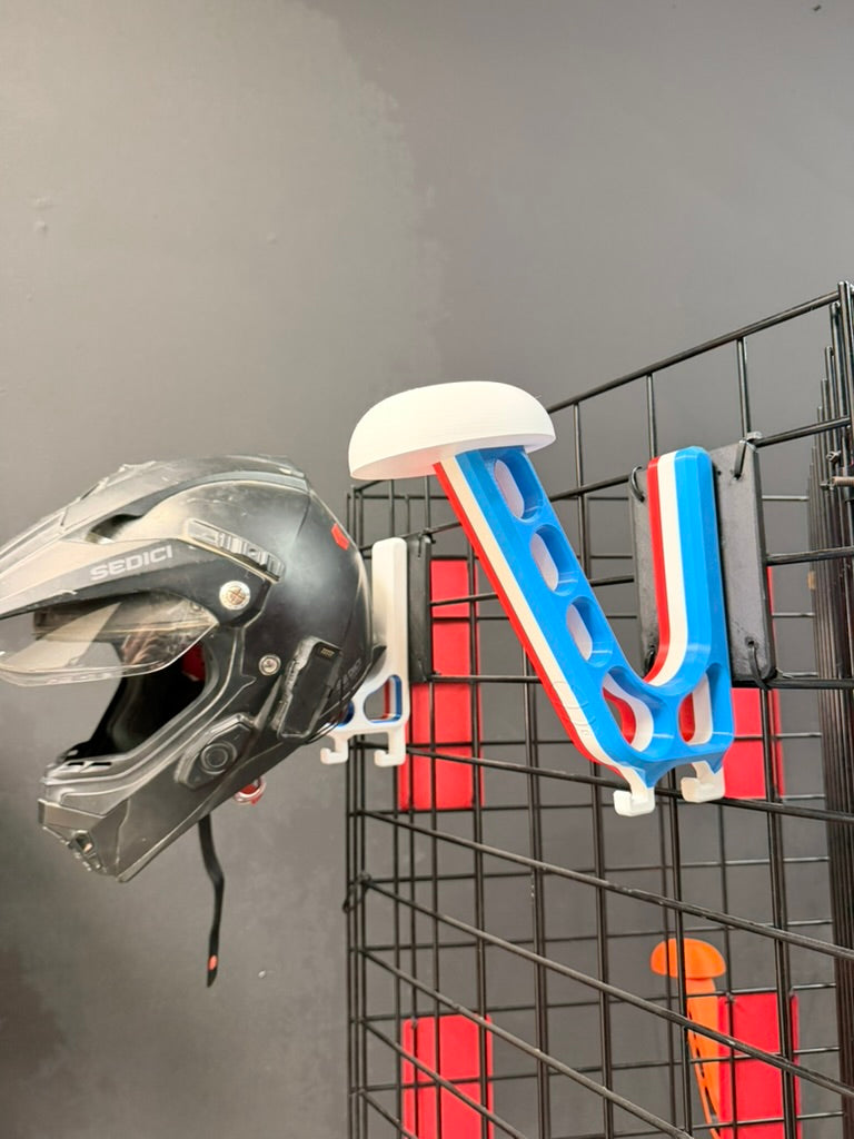 Helmet hanging on a wall mount against a gray background